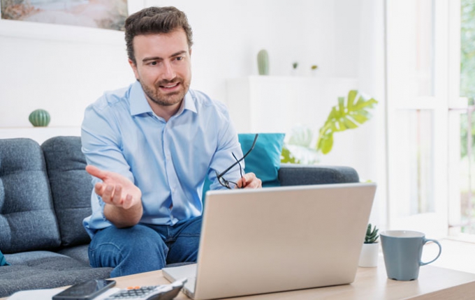 A man has a virtual conversation using his laptop.