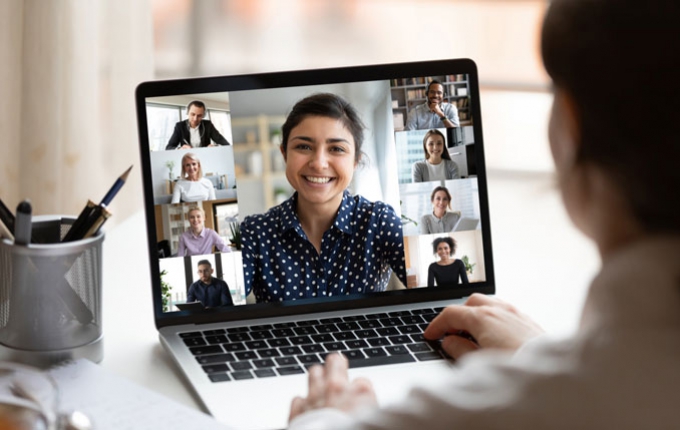 A woman attends a virtual meeting on her laptop.