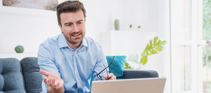 A man has a virtual conversation using his laptop.