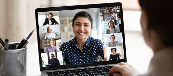 A woman attends a virtual meeting on her laptop.